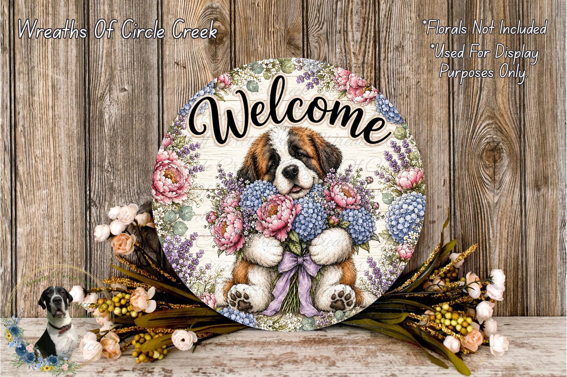 A decorative welcome sign featuring a dog holding a bouquet of flowers, placed on a wooden surface with a floral arrangement and some flowers nearby.
