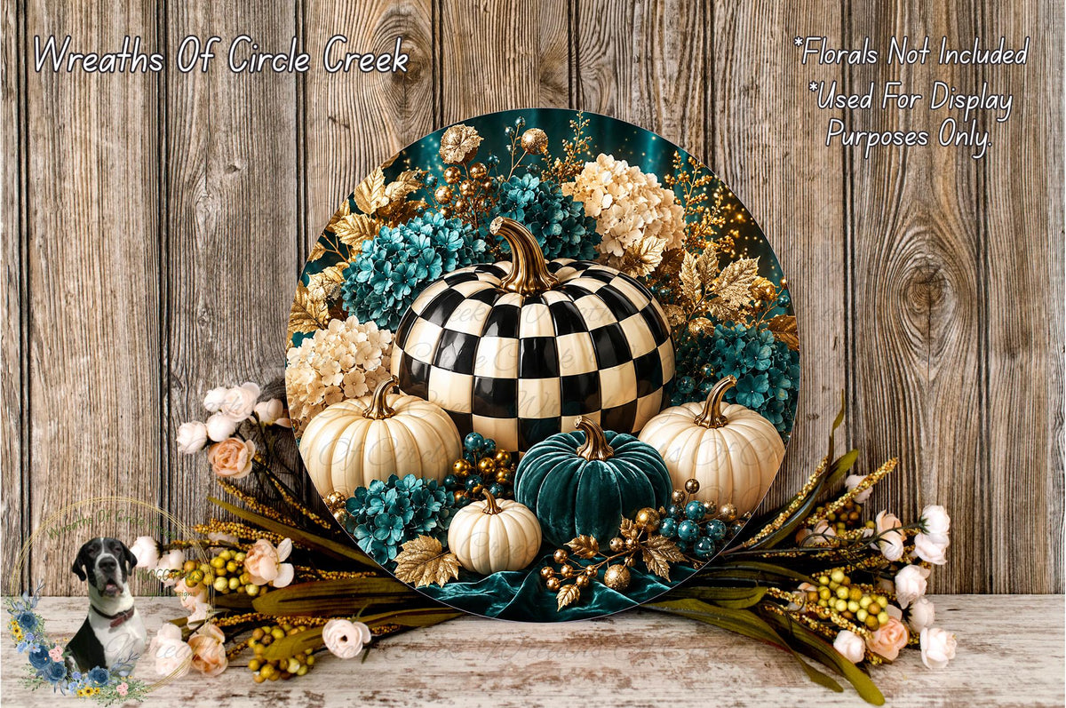 A decorative wreath made of various materials, including a large black and white checkerboard pumpkin, white pumpkins, blue and green flowers, and other fall-themed elements, displayed on a wooden surface.