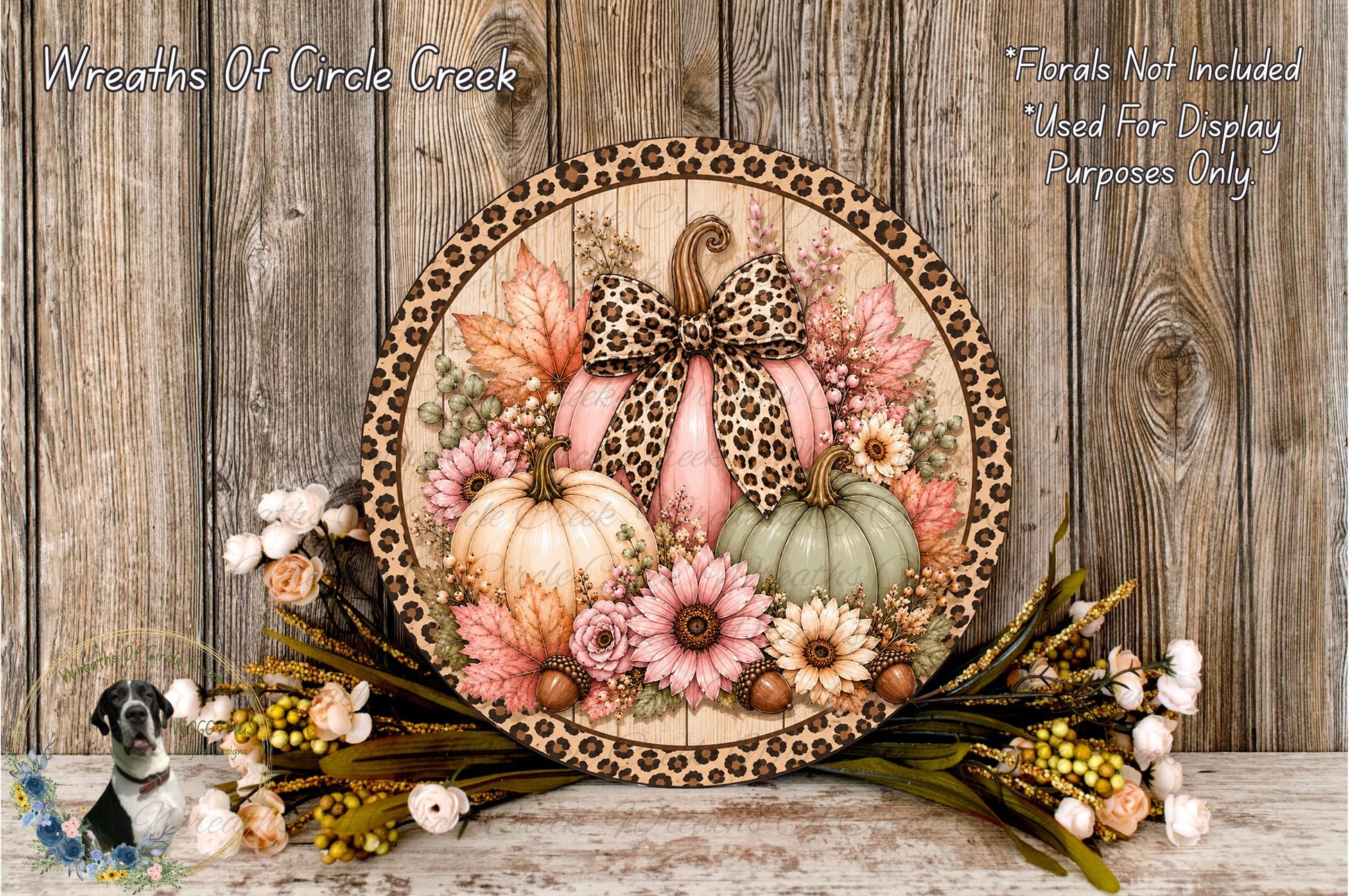 A decorative wreath made of a wooden frame with a leopard print border, featuring pumpkins, flowers, and leaves.