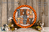 a Halloween-themed decoration with a large orange sign that says "TRICK TREAT" surrounded by a floral arrangement and a wooden background.