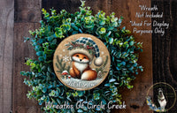 A wreath made of green foliage and a small fox wearing a hat, with the text "Let it snow" and "Wreaths of Circle Creek" displayed.
