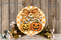 A Halloween-themed wreath with two jack-o'-lanterns and a bow, placed on a wooden surface with flowers and greenery.