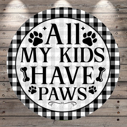 A circular sign with the text "ALL MY KIDS HAVE PAWS" in bold letters, surrounded by paw prints and bones.