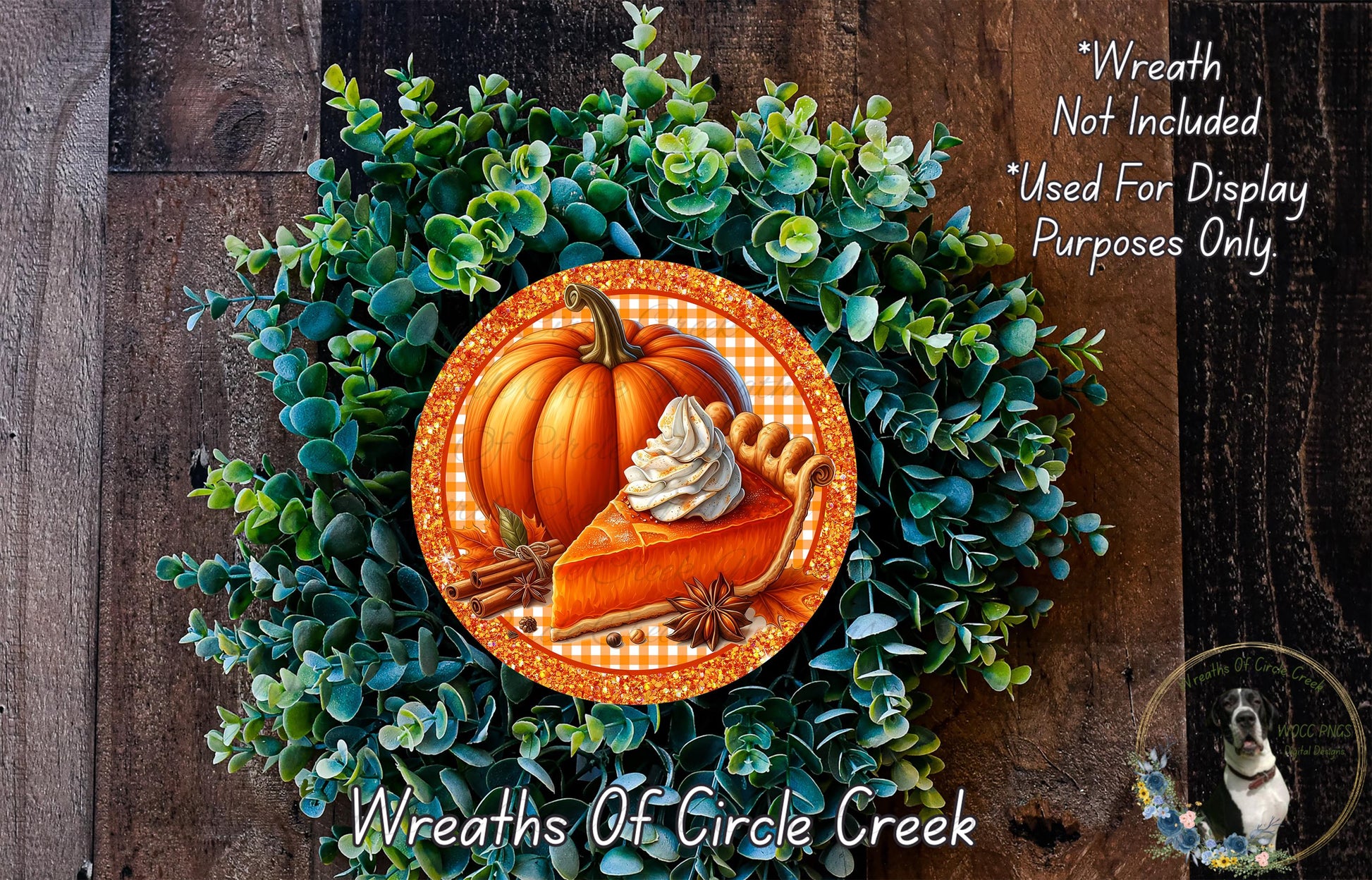 A wreath made of green foliage and a pumpkin with whipped cream on top, placed on a wooden surface.