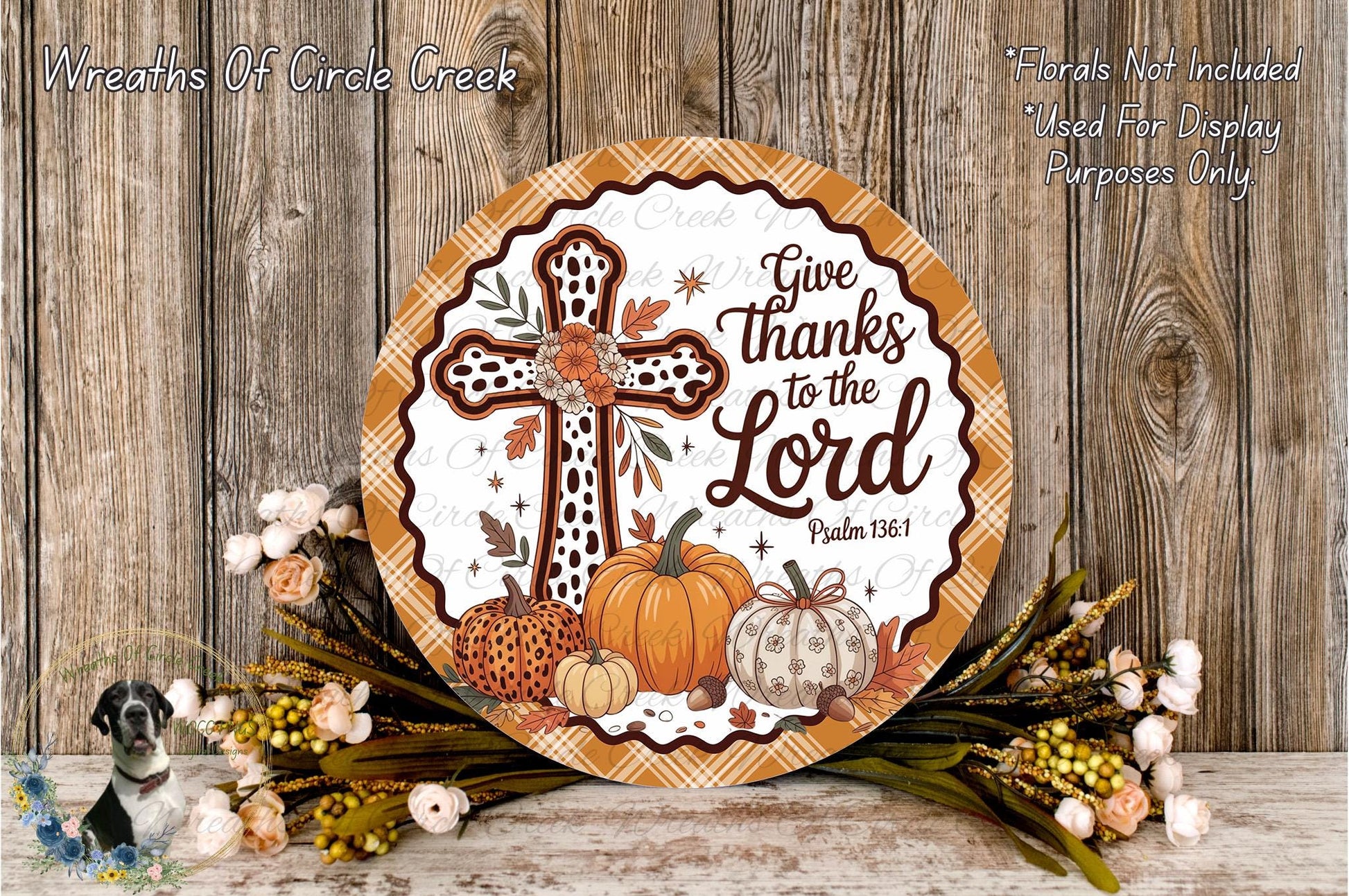 a decorative plate with a cross and fall-themed elements, such as pumpkins and flowers, placed on a wooden surface.