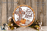 a decorative plate with a cross and fall-themed elements, such as pumpkins and flowers, placed on a wooden surface.