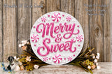 a decorative sign with the words "Merry & Sweet" written on it, surrounded by pink and white candy-like elements and flowers. The sign is placed on a wooden surface, and there are additional floral elements in the background.