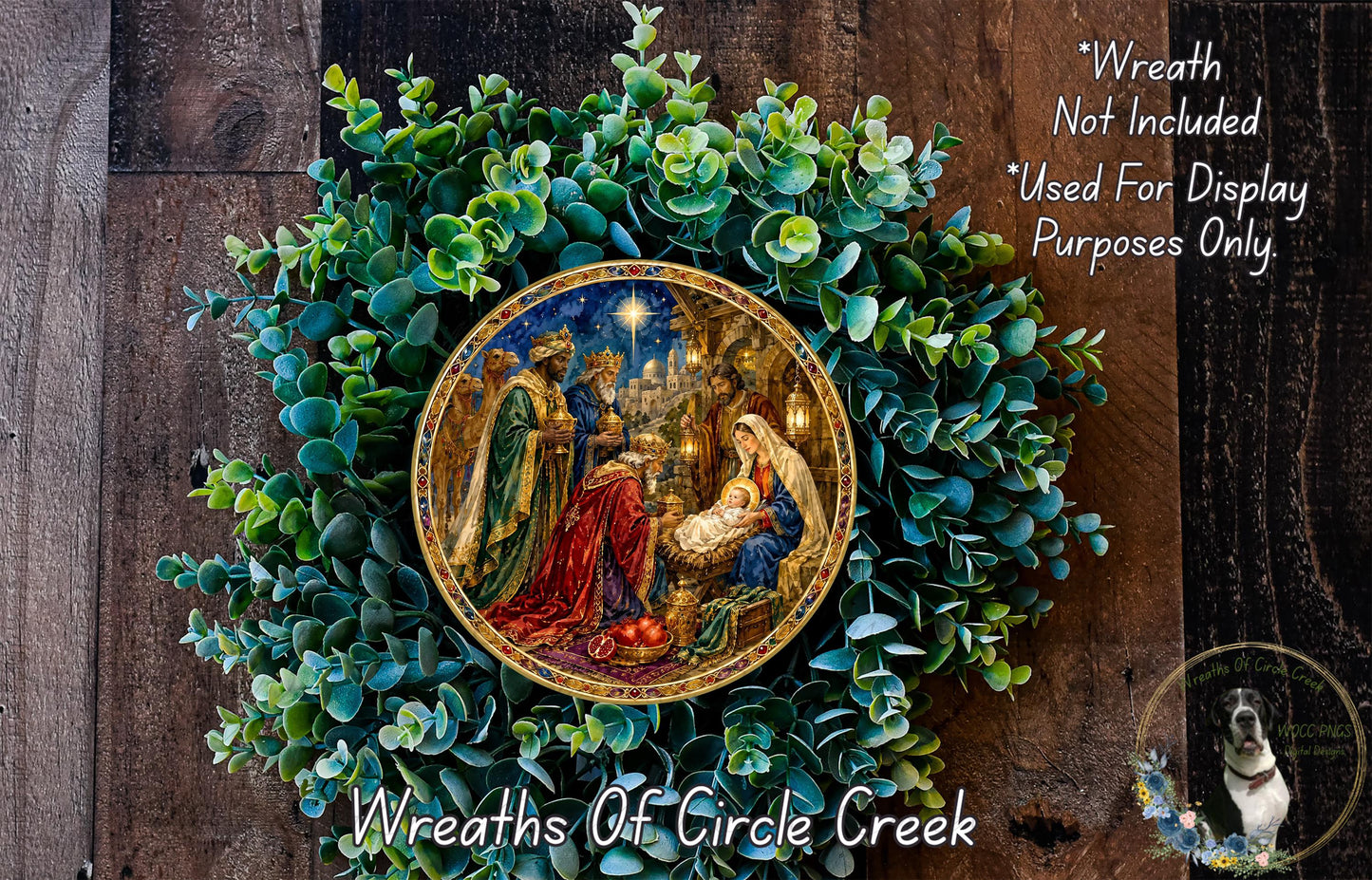 A wreath with a painting of the Nativity scene, surrounded by greenery, and a dog in the corner.