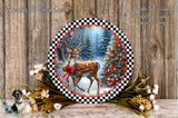 A decorative plate featuring a deer in a snowy forest scene, surrounded by a wreath of flowers and a Christmas tree.