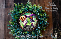 a wreath with a picture of two witches on it
