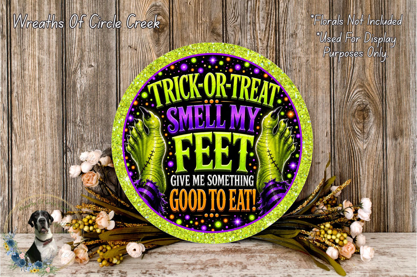 a Halloween-themed sign with a humorous message about trick-or-treating and smelling one's feet. The sign is surrounded by a floral arrangement and placed on a wooden surface.