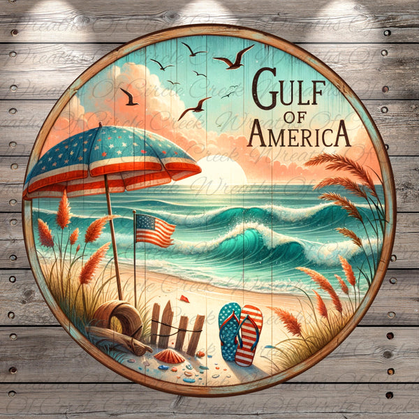 A circular wooden sign with a beach scene, featuring an American flag, a beach umbrella, and a pair of flip-flops, with a sunset and waves in the background.