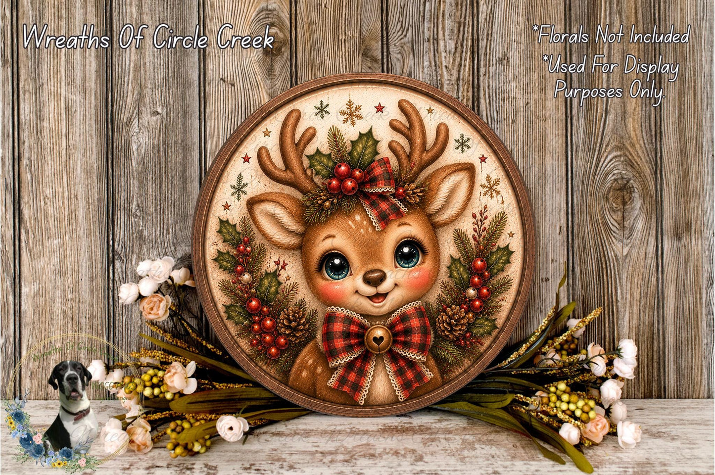 A decorative wreath featuring a smiling deer with antlers, surrounded by flowers and greenery, placed on a wooden surface.