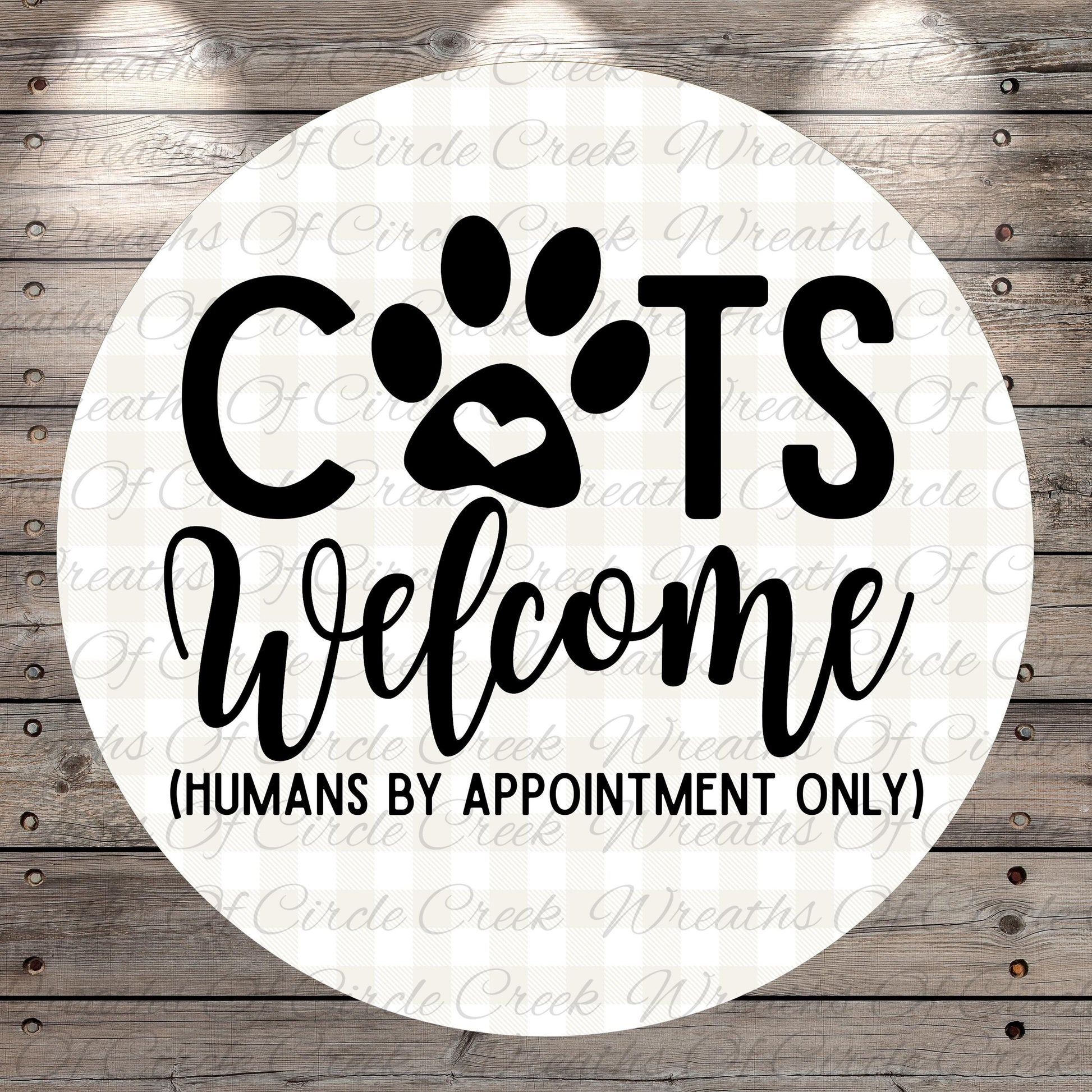 a circular sign with the text "CATS Welcome (HUMANS BY APPOINTMENT ONLY)" written on it.