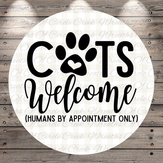 a circular sign with the text "CATS Welcome (HUMANS BY APPOINTMENT ONLY)" written on it.