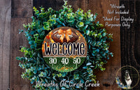 a wreath with a football on it, surrounded by greenery, and a sign that reads "Welcome 310 40 50".