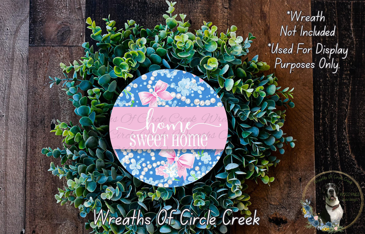 a wreath made of green leaves and flowers, with a circular sign in the center that says "home sweet home".
