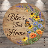 A wooden sign with a floral border and a butterfly, displaying the text "Bless This Home" surrounded by colorful flowers and butterflies.