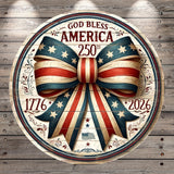 A circular wooden sign with a large bow made of red, white, and blue ribbons, surrounded by stars and the text "God Bless America" and "250th" on it.