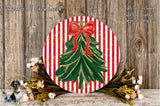 a festive Christmas wreath with a red bow, surrounded by a variety of flowers and greenery, set against a rustic wooden background.