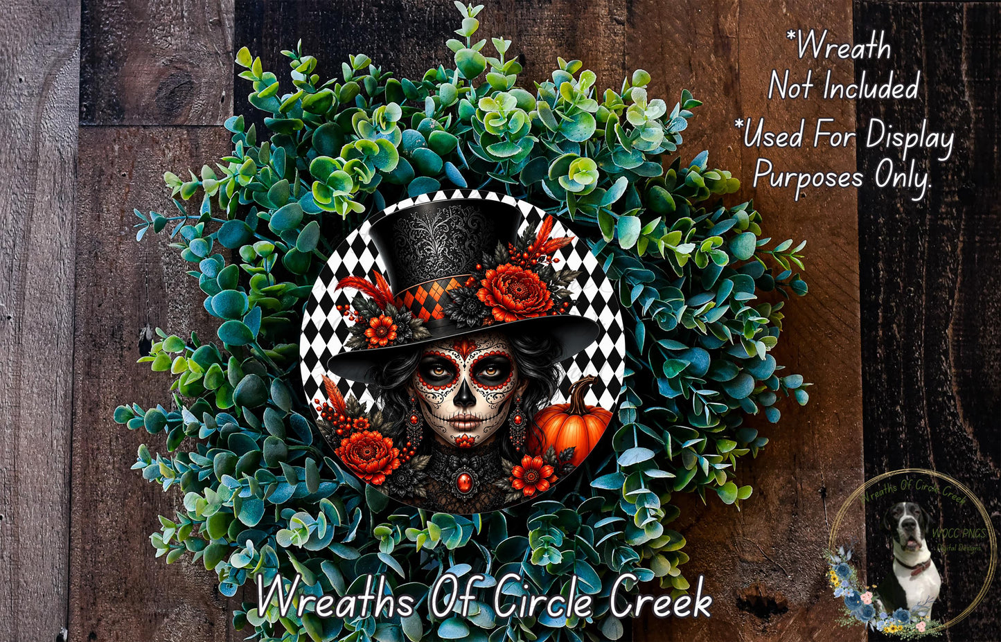 A wreath featuring a woman's face with a skull design, surrounded by green foliage and a pumpkin.