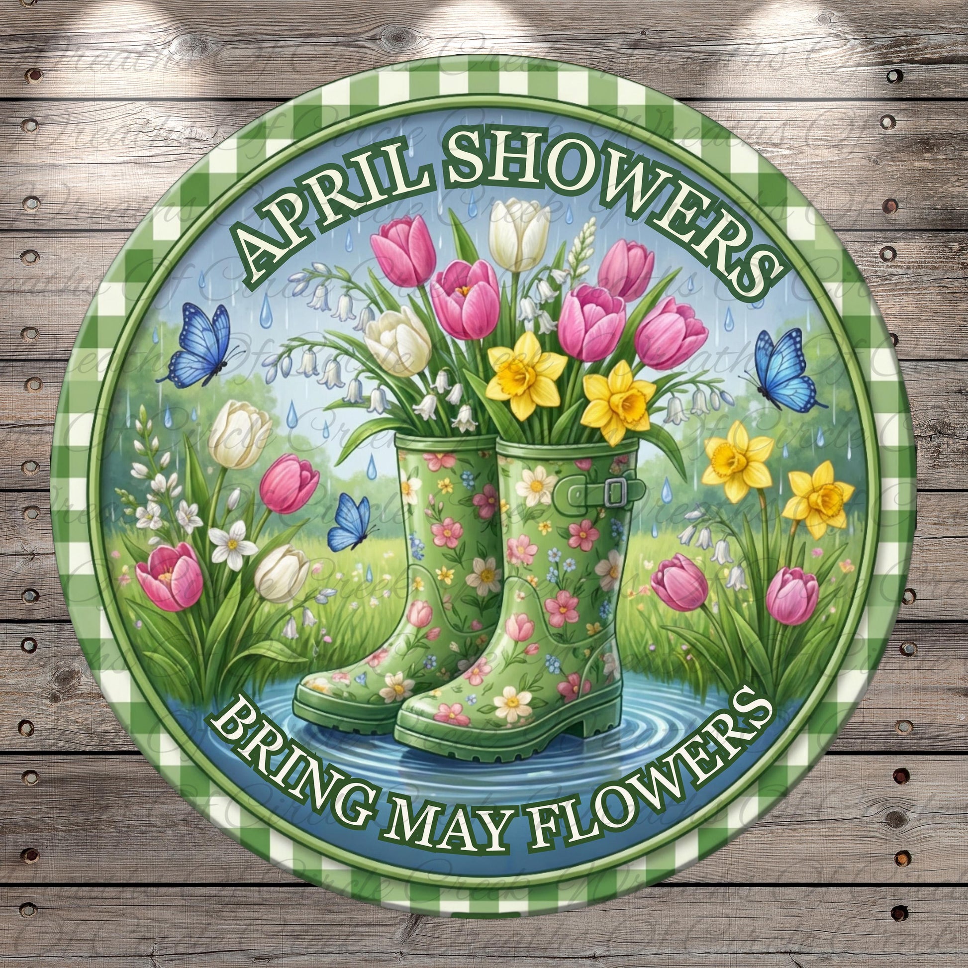 A circular sign with a floral design, featuring a pair of green rain boots in the center surrounded by colorful flowers, butterflies, and a pond. The sign has the text "April Showers Bring May Flowers" written around the edge.