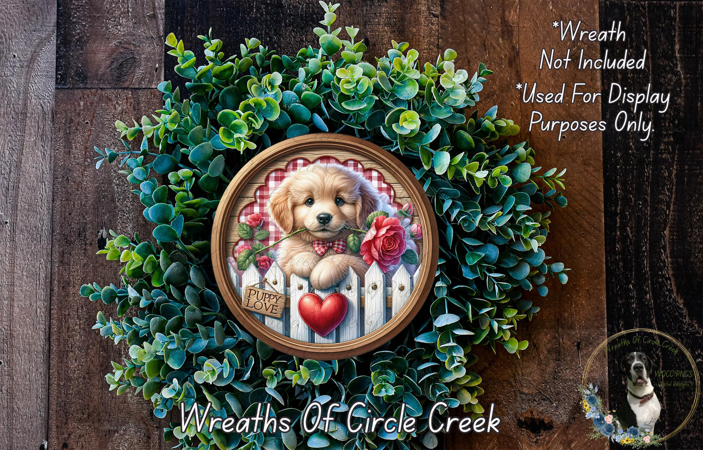 A wreath with a golden retriever puppy wearing a red bow tie and holding a red rose, surrounded by green foliage.