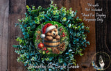 A wreath featuring a bear wearing a Santa hat, surrounded by pine cones, berries, and greenery, with a text overlay that reads "Wreath Not Included * Used For Display Purposes Only" and "Wreaths of Circle Creek".