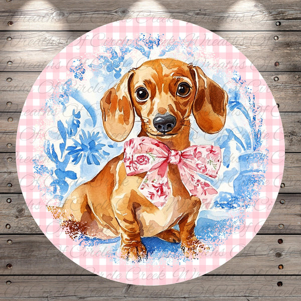 A dachshund dog wearing a pink bow tie is the central focus of the image, set against a background of blue and white floral patterns.