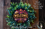 A wreath made of green leaves and a large illuminated sign that says "WELCOME".