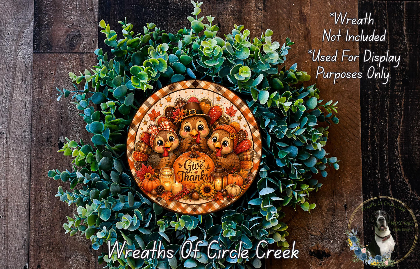 A wreath made of green foliage and featuring a circular design with a turkey, pumpkin, and the text "Give Thanks" surrounded by other fall-themed elements.