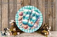 A circular sign with a beach-themed design, featuring a pair of flip-flops, seashells, and flowers, placed on a wooden surface.