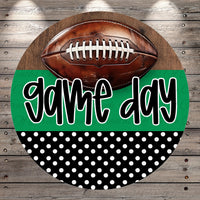 A football is placed on top of a green and black polka dot background with the text "game day" written in a stylized font.