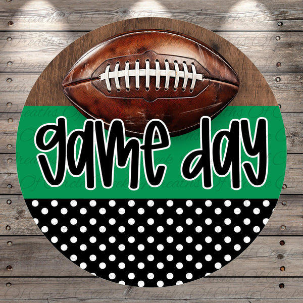 A football is placed on top of a green and black polka dot background with the text "game day" written in a stylized font.