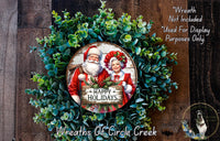 A wreath made of green leaves and featuring a Santa Claus and Granny Claus holding a sign that says "Happy Holidays".