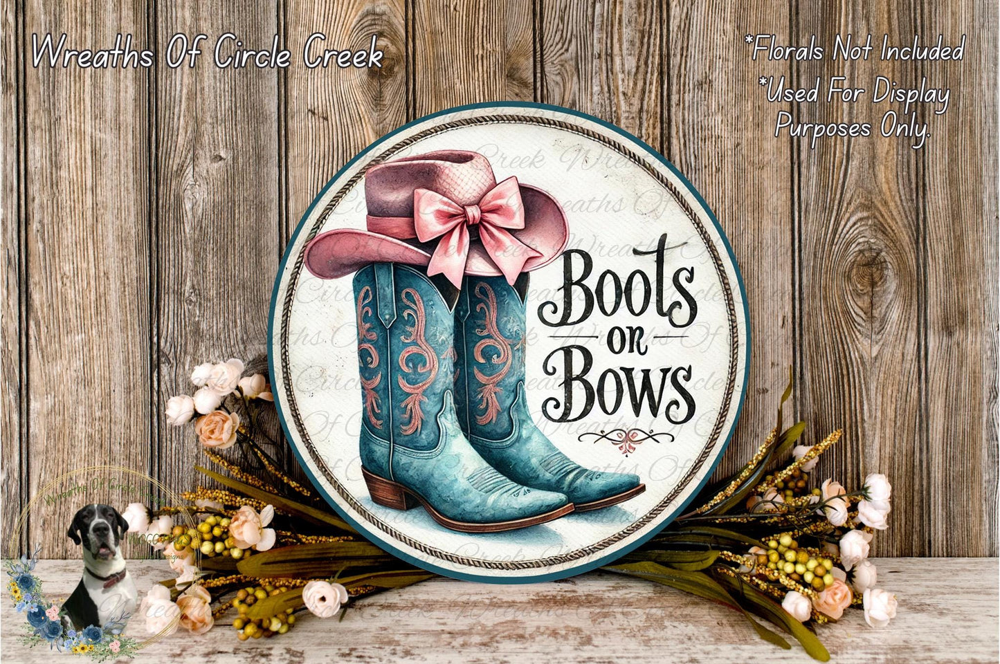 a decorative sign with the text "Boots on Bows" and a pair of blue cowboy boots with a pink bow. The sign is surrounded by a floral arrangement and placed on a wooden surface.