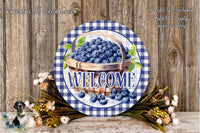 a welcome sign with a basket of blueberries and flowers, set against a wooden background.