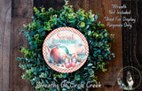 a wreath made of green leaves and a red and white checkered plate with the text "Sweet Summertime" and an illustration of a peach and flip flops.