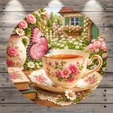 A pink butterfly perches on a teacup with pink flowers, set against a backdrop of a garden with pink roses and a wooden house.