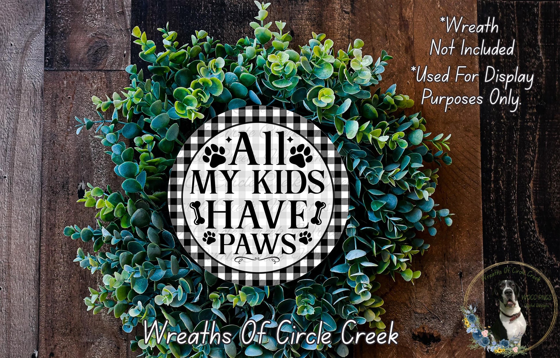 A wreath made of green leaves and a circular sign with the text "All My Kids Have Paws" in the center.