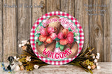 a round sign with a floral design, surrounded by a wreath of flowers and a wooden background.