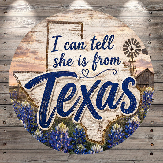 a circular sign with the text "I can tell she is from Texas" written on it. The sign is set against a background that includes a Texas state map, a windmill, and a field of blue flowers.