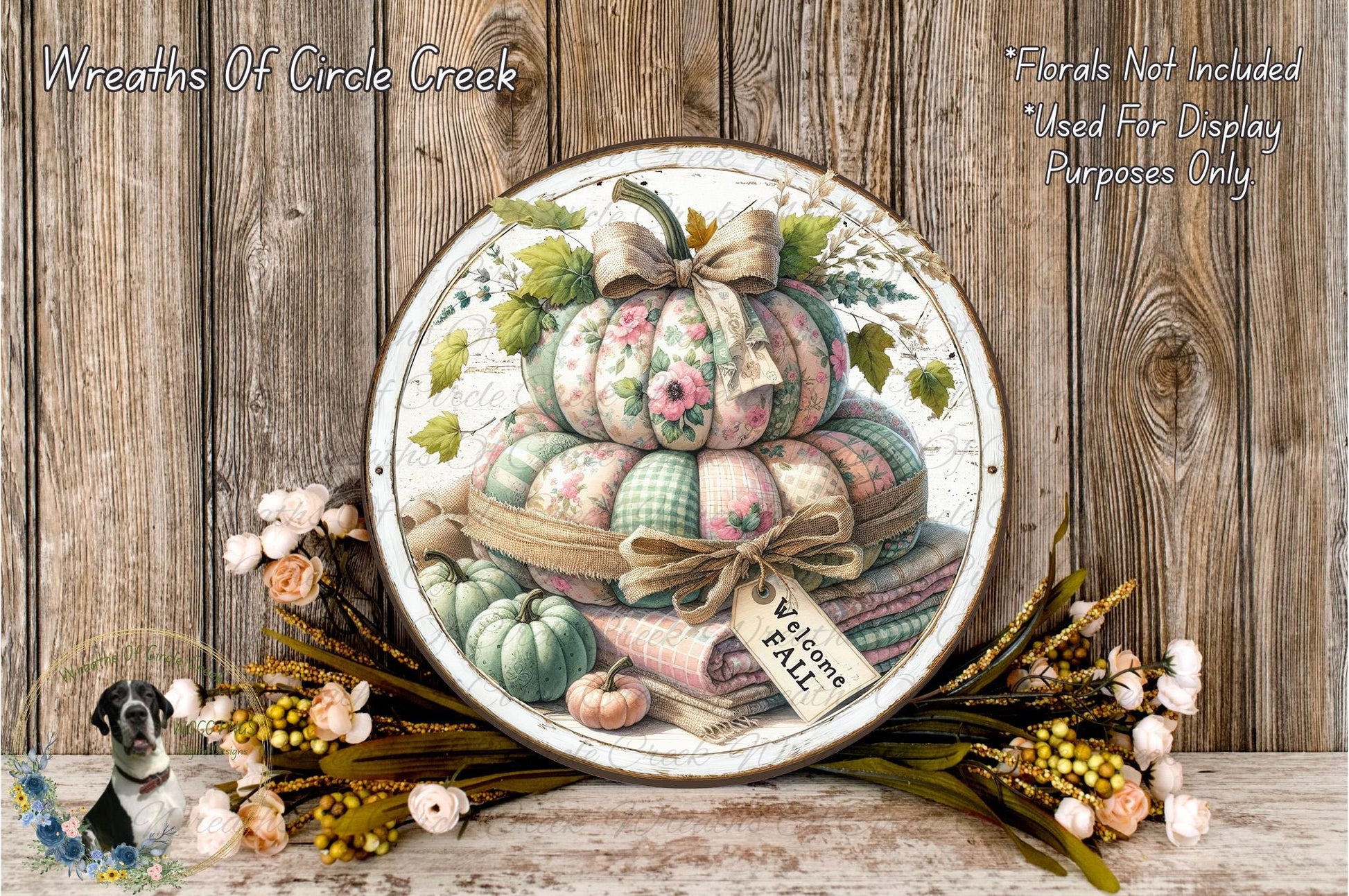 a decorative arrangement of pumpkins and flowers, with a sign that reads "Welcome Fall". The pumpkins are stacked on top of each other, and there are flowers surrounding the arrangement. The wooden background adds a rustic touch to the overall presentation.