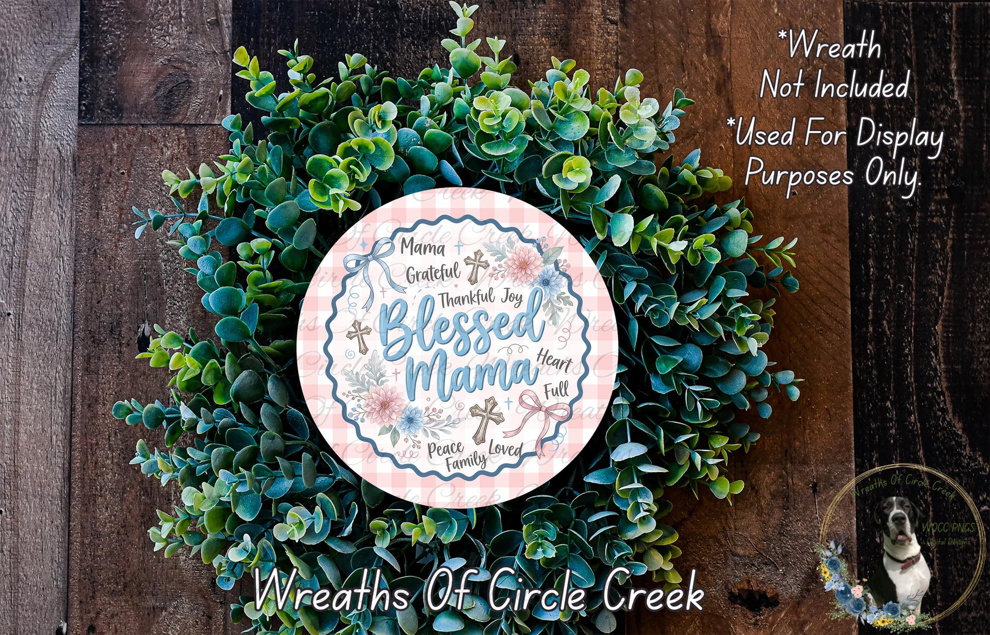 A wreath made of green leaves and flowers, with a pink and blue sign in the center that says "Mama Grateful, joyful, full of peace, family".