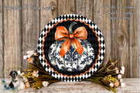 a decorative pumpkin wreath with a black and white floral pattern, a large orange bow, and a wooden background.