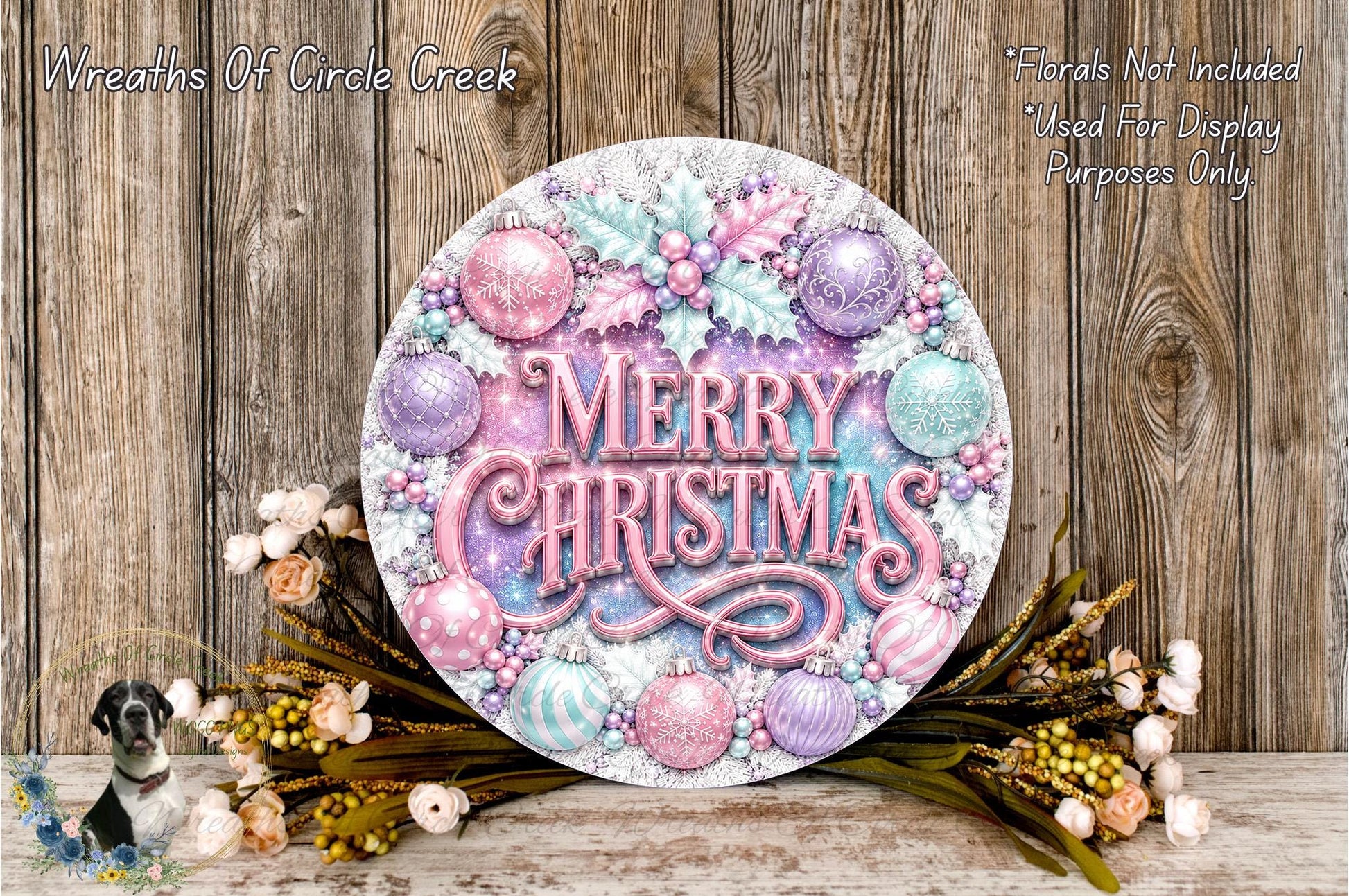 A festive wreath with the text "Merry Christmas" displayed prominently, surrounded by various ornaments and flowers. The wreath is placed on a wooden surface, and there is a small dog figurine in the background.