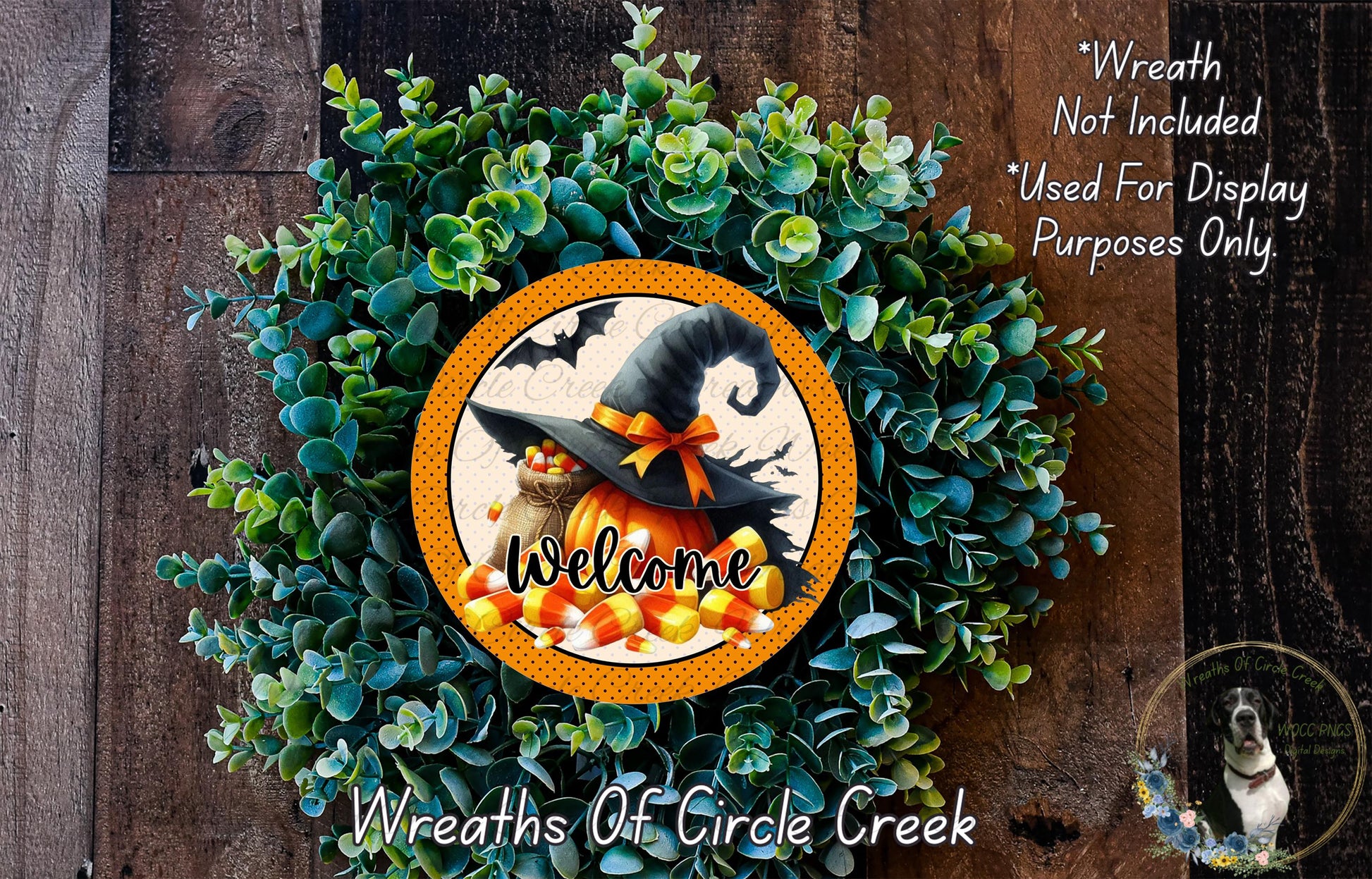 a Halloween-themed wreath with a witch's hat, a pumpkin, and candy corn, surrounded by greenery. The wreath is displayed on a wooden surface, and there is a text overlay that reads "Welcome Wreath Not Included * Used For Display Purposes Only".