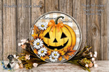 a Halloween-themed wreath with a jack-o-lantern design, surrounded by flowers and autumn leaves. The wreath is displayed on a wooden surface, creating a festive and seasonal atmosphere.