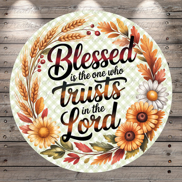 A circular design with a floral border and text that reads "Blessed is the one who trusts in the Lord".