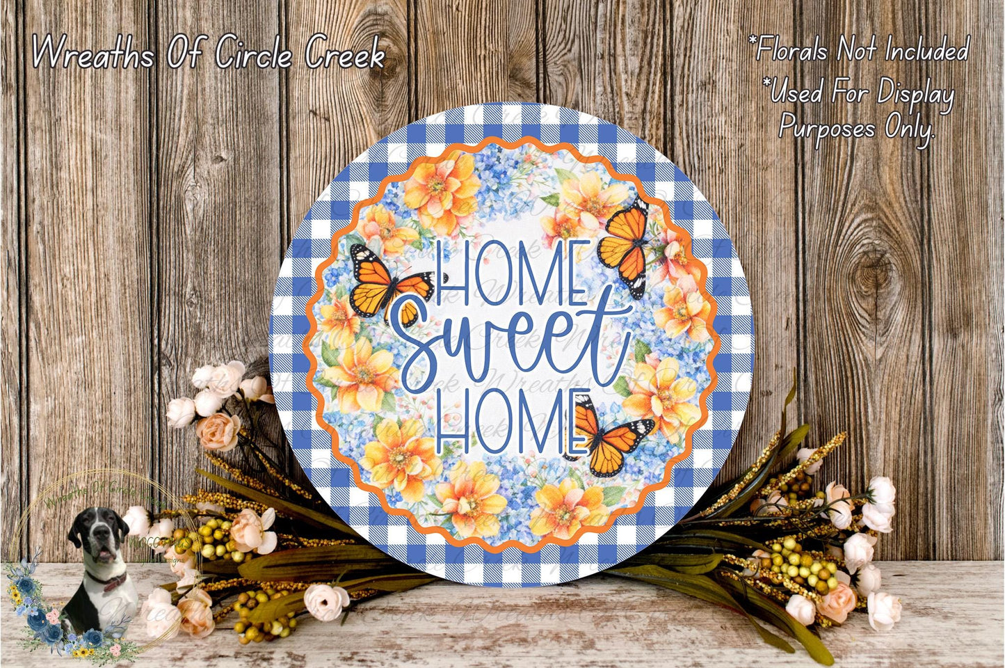 a decorative sign with the text "Home Sweet Home" surrounded by a floral arrangement and butterflies. The sign is placed on a wooden surface, and there are flowers and butterflies in the background.